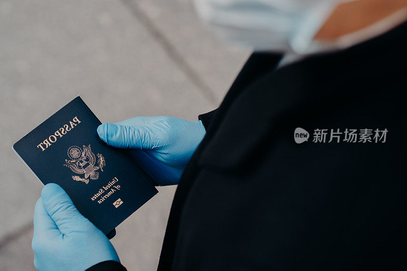 未知男子游客戴橡胶医用手套，持有护照，在大流行疾病传播期间不能旅行，防止冠状病毒。对世界旅游业的负面影响。Covid - 19，危险，病毒